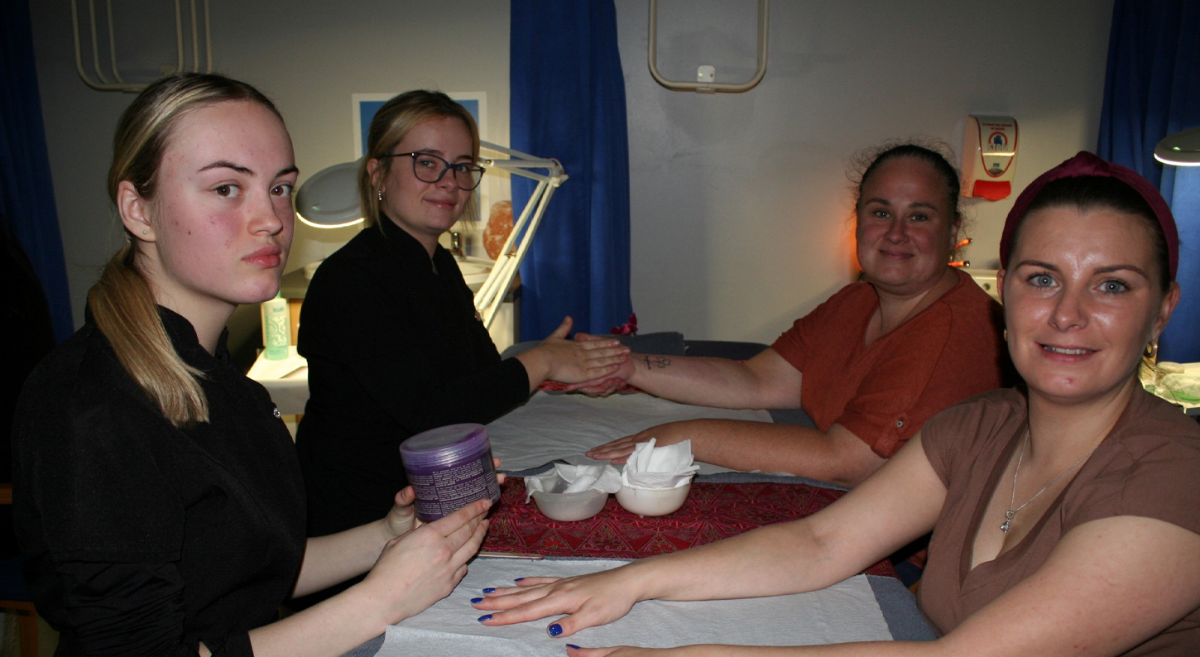 two female students on the left delivering treatments to two women on the right